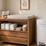 Nursery diaper pail with odor lock system next to a changing table