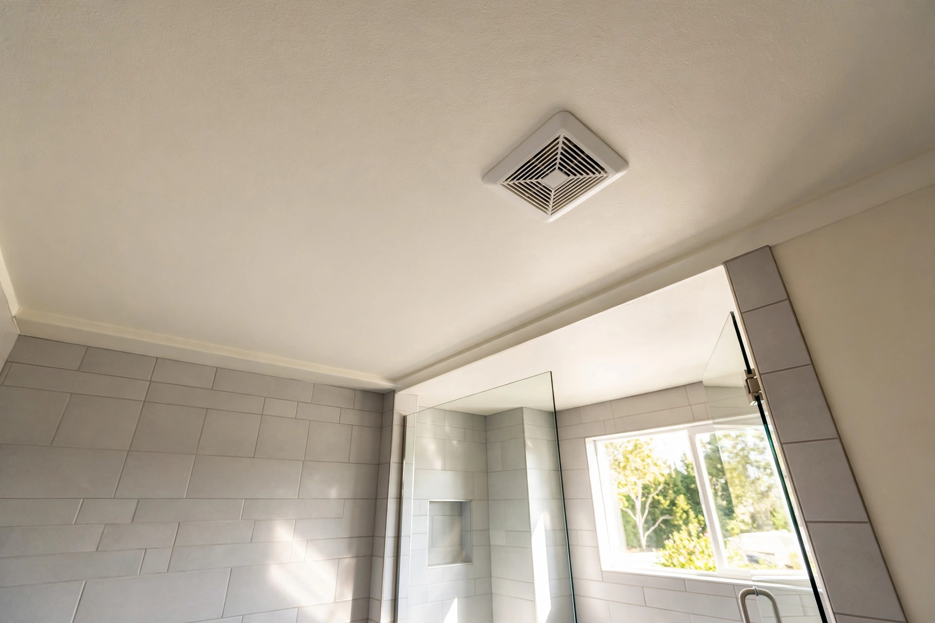best quiet bathroom exhaust fan reviews usa: Quiet bathroom exhaust fan installed in a ceiling, shown in a bright modern American bathroom