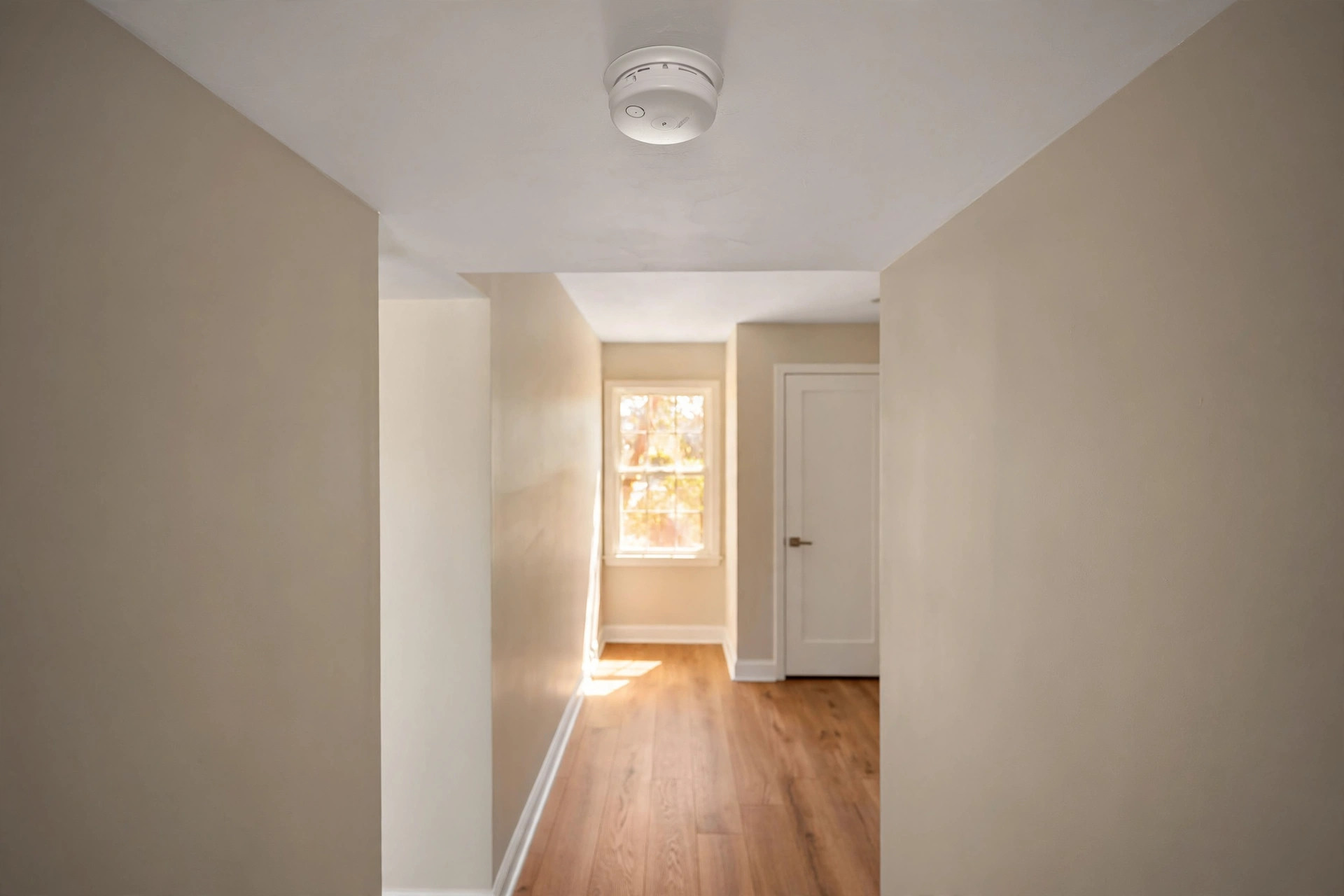 best hardwired smoke detector reviews usa: Hardwired smoke detector mounted on a hallway ceiling