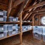 top rated attic storage solutions for cold climates: Organized attic storage in a cold climate home with sealed bins on wooden shelves