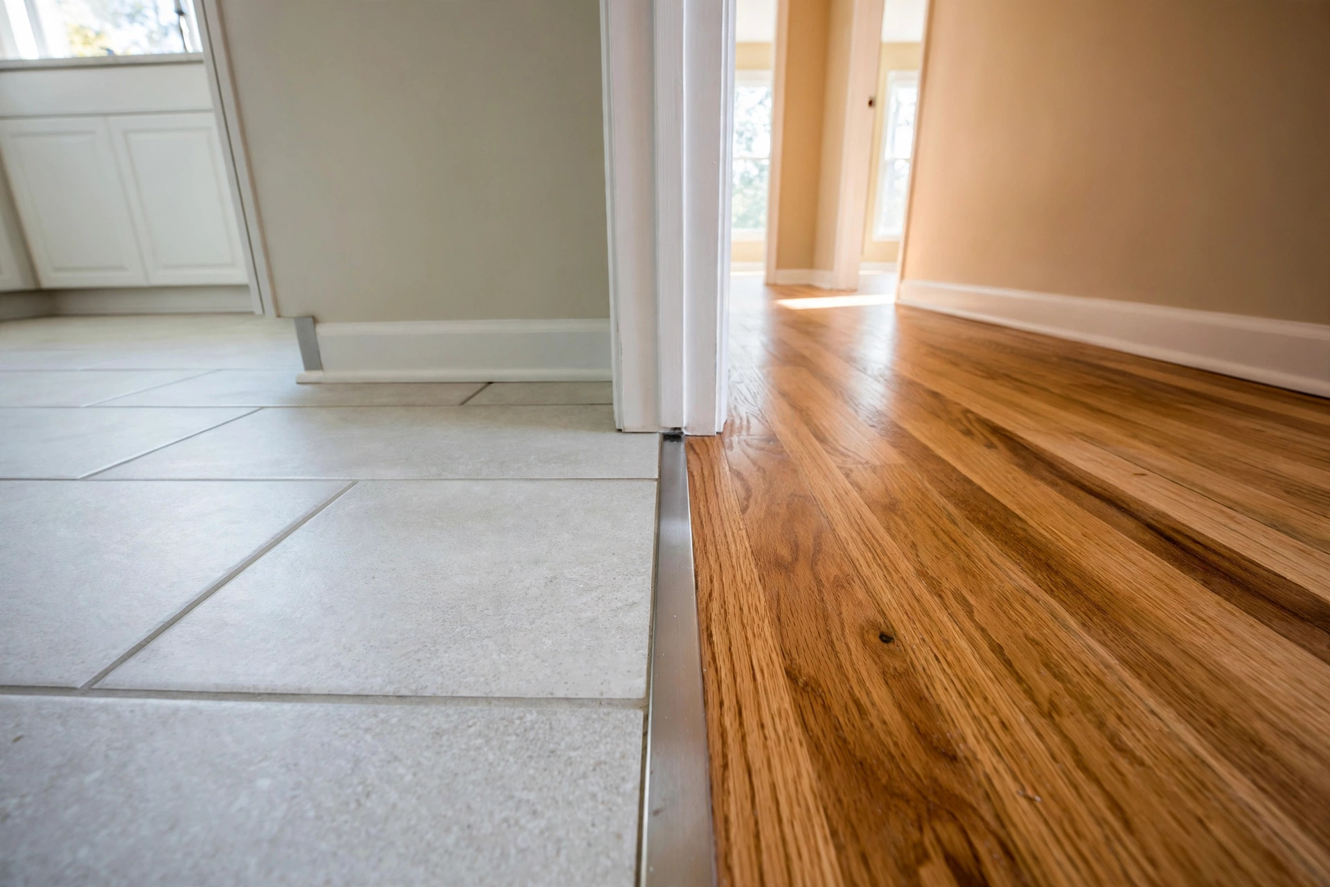 flooring transition from tile to wood ideas: Floor transition strip between tile floor and wood floor in an American home