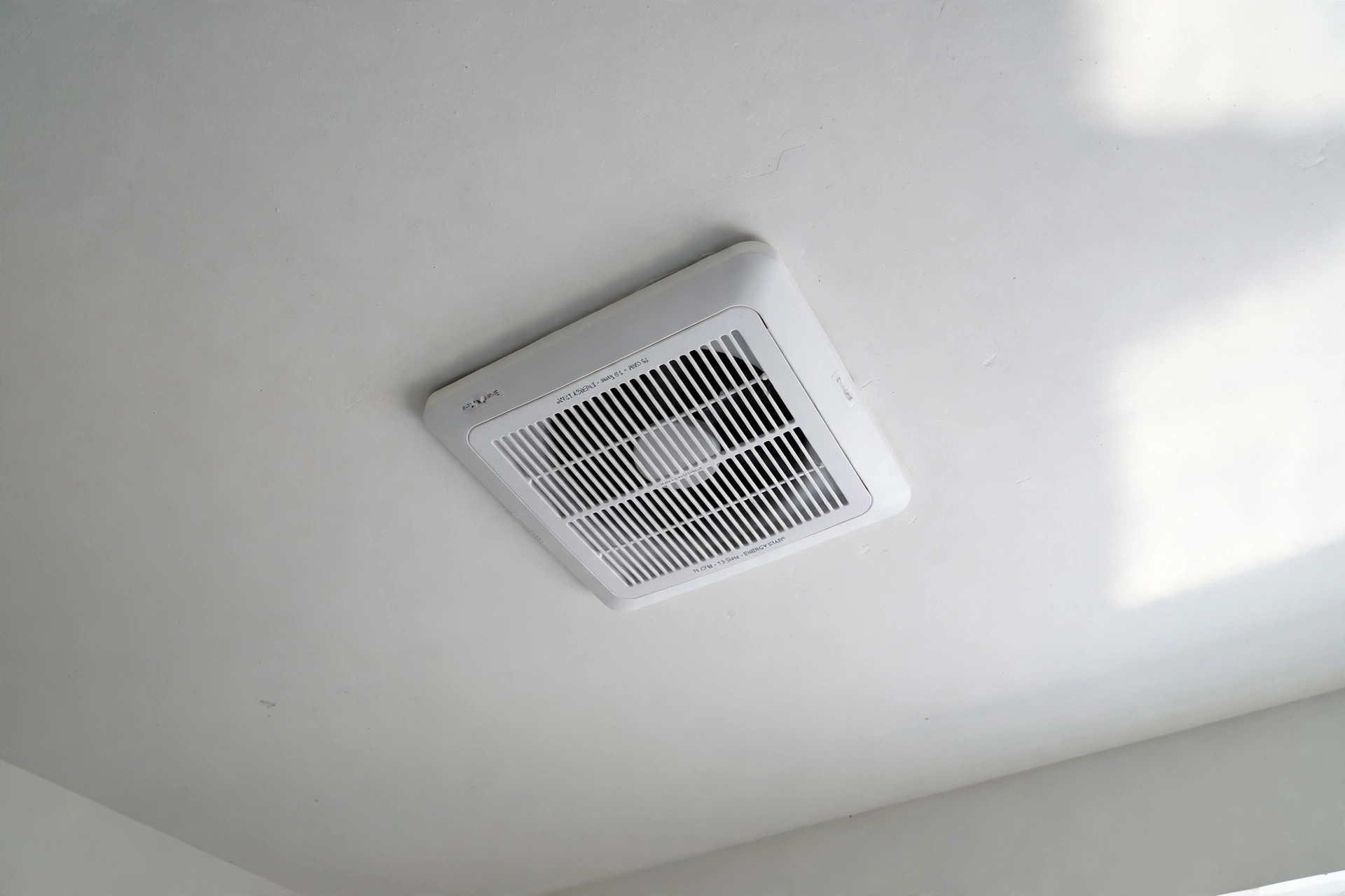 White ceiling exhaust fan installed in a bathroom — quiet exhaust fans where to buy usa