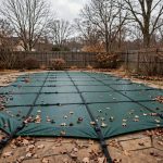 best pool cover for winter reviews: A backyard swimming pool covered with a winter pool cover