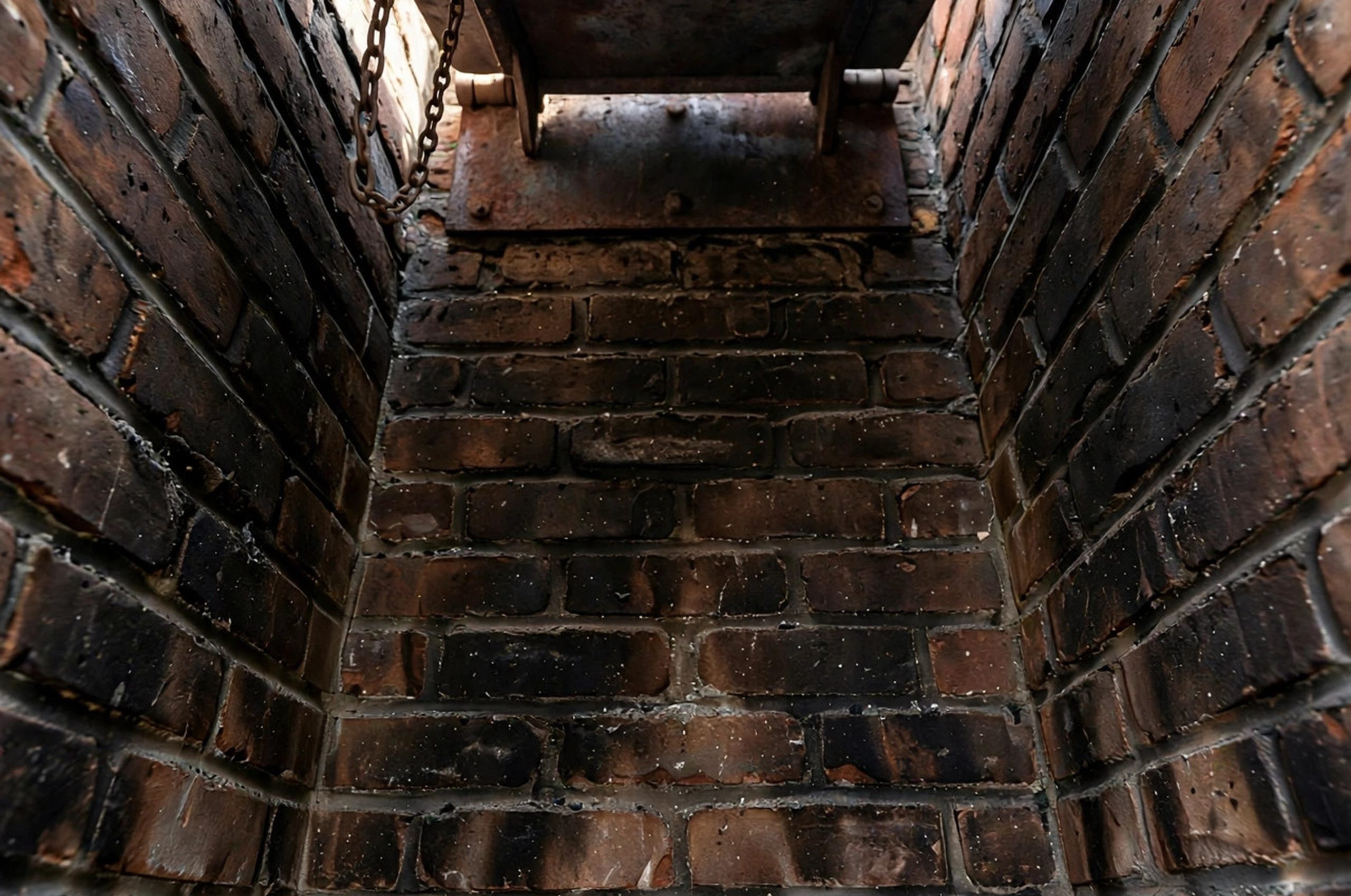 Fireplace Damper Stuck How to Fix: Inside of a fireplace firebox showing the damper plate